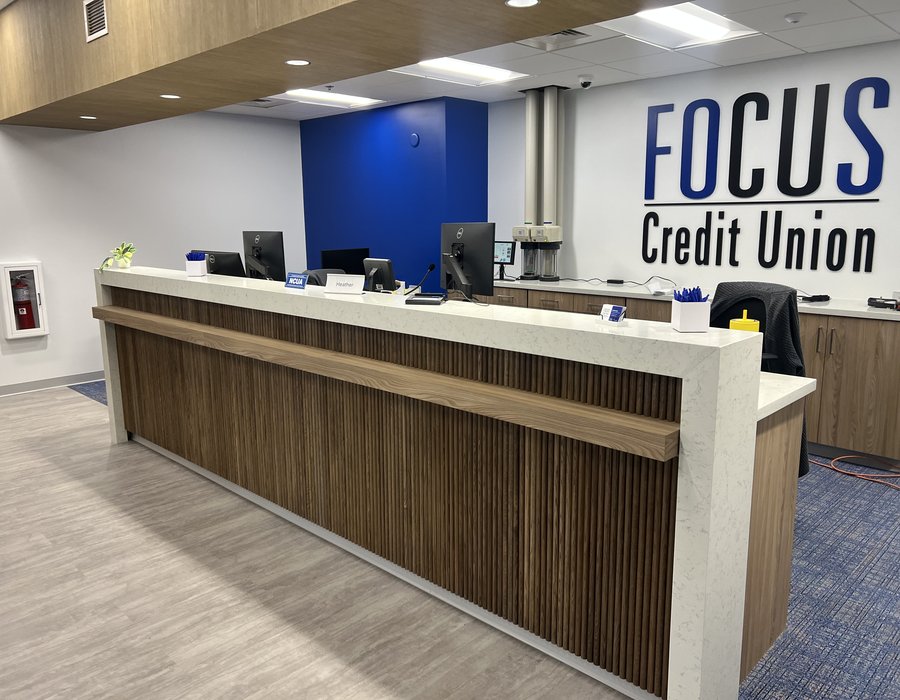 Credit union greeter desk with slatted wood millwork dividers under construction by Robertson Cabinets