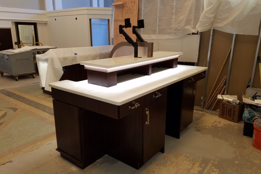 Custom reception desk with backlit countertop being built in Robertson Cabinets shop Ohio